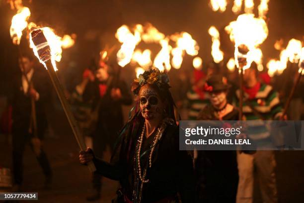 Revellers parade through the streets of Lewes in East Sussex, southern England, on November 5 during the traditional Bonfire Night celebrations. -...