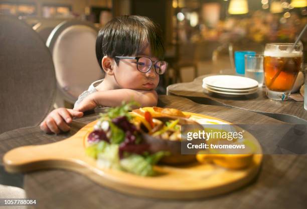 4 years old young boy not interested with food served. - picky eater stockfoto's en -beelden