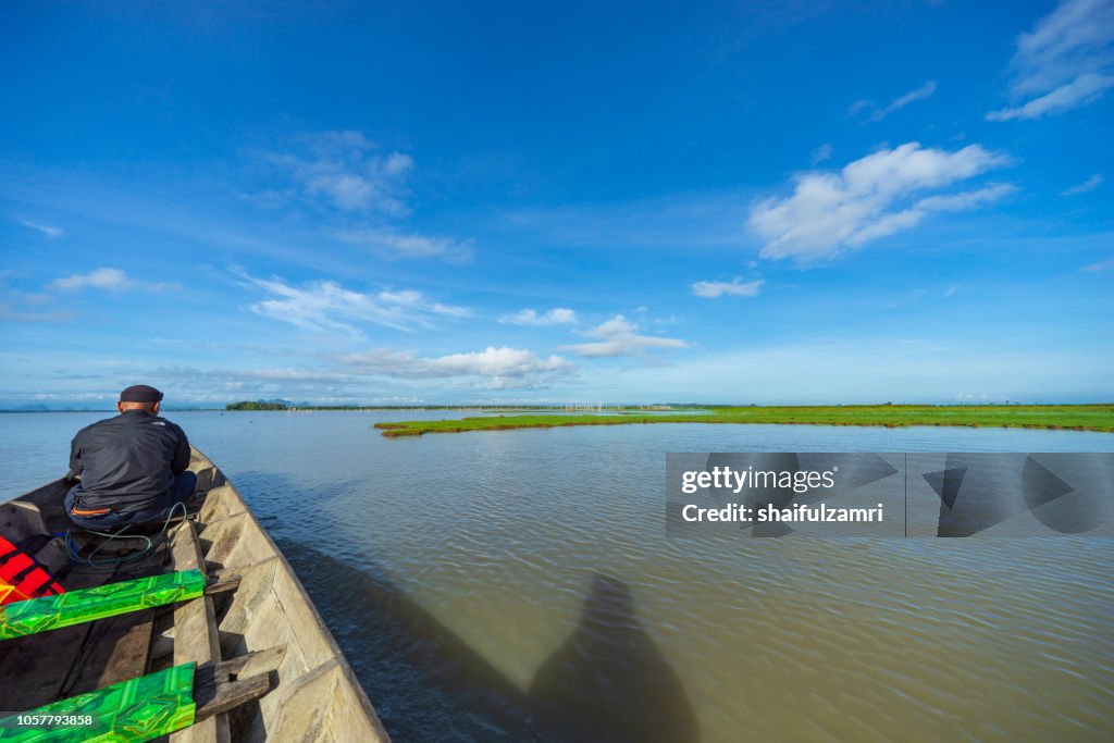 Tourist enjoying a morning view of lake Thale Noi, Phatthalung, Thailand.