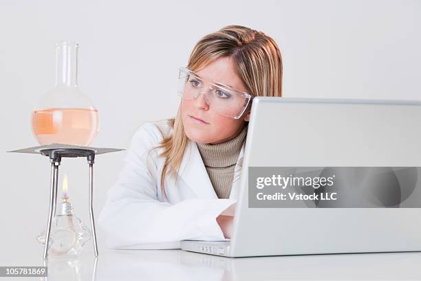 Chemist Looking At Flask Of Liquid, Foto de stock