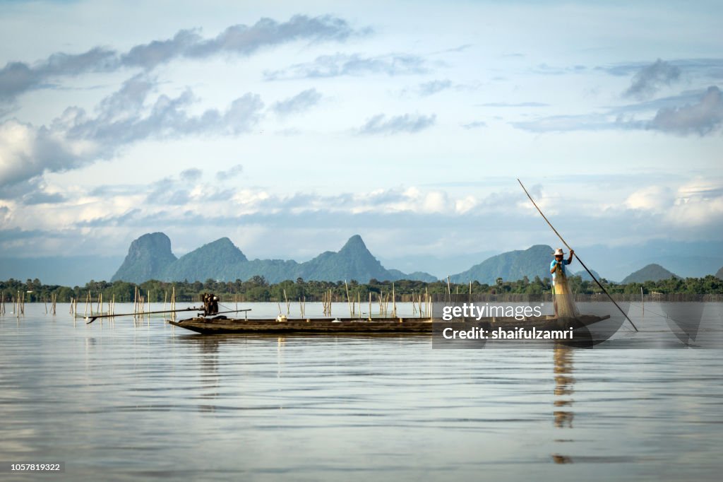 Fishermen at work in long boats, Thailand near Phatthalung province at lake Thale Noi.