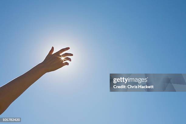 hand in front of a sun flare in the sky - hands sun stock-fotos und bilder