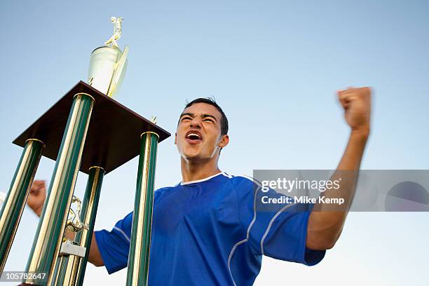 trophy in front of cheering soccer player - championship day one stock pictures, royalty-free photos & images