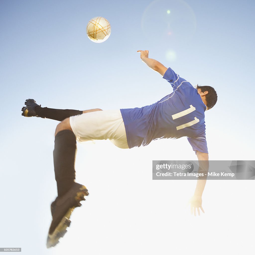 Soccer player jump kicking