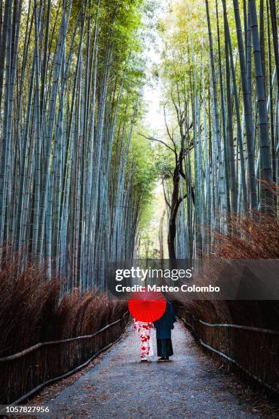 japanese couple in kimono walking in bamboo grove, kyoto, japan - arashiyama stock pictures, royalty-free photos & images