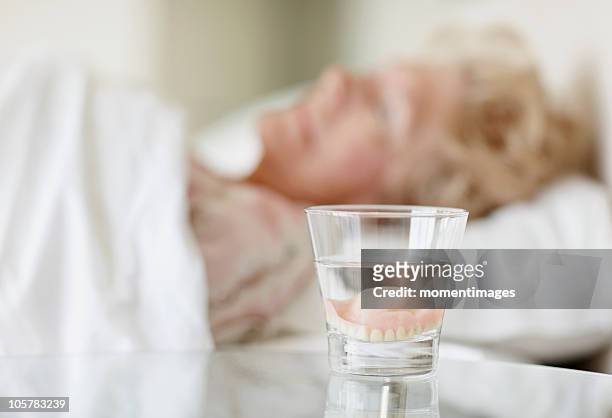 dentures in a glass of water - bedside table stock pictures, royalty-free photos & images
