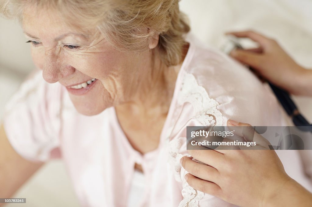 Nurse examining patient with a stethoscope