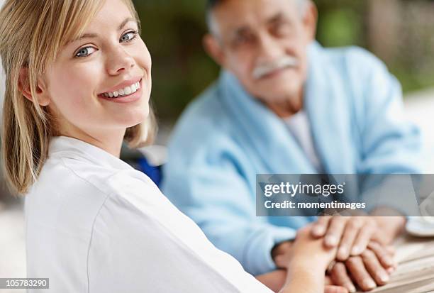 Nurse And Senior Man Holding Hands High-Res Stock Photo
