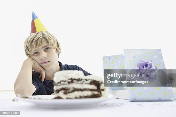 tired young boy at a birthday party - gateau anniversaire fond blanc photos et images de collection