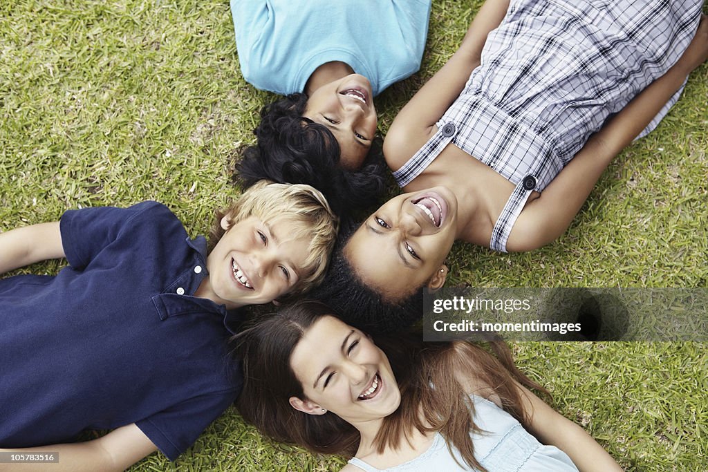 Four friends lying on the grass