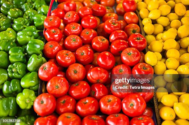 display of peppers tomatoes and lemons - produce aisle photos et images de collection