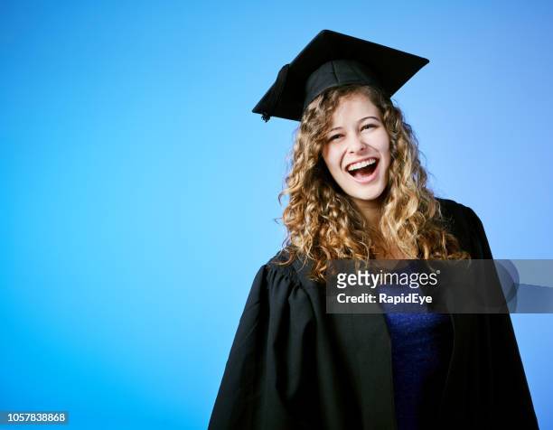 beautiful young graduate smiles in delight at her success - student coloured background stock pictures, royalty-free photos & images