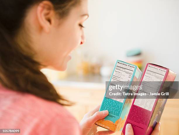 woman reading nutrition facts on food packaging - examining food stock pictures, royalty-free photos & images
