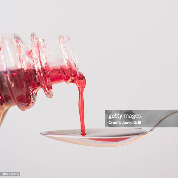 cough syrup being poured onto spoon - cough medicine stock pictures, royalty-free photos & images