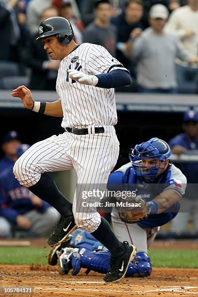 Alex Rodriguez of the New York Yankees scores past the tag attempt of catcher Matt Treanor of the Texas Rangers in the bottom of the second inning of...