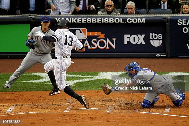 Alex Rodriguez of the New York Yankees scores past the tag attempt of catcher Matt Treanor of the Texas Rangers as C.J. Wilson backs him up in the...