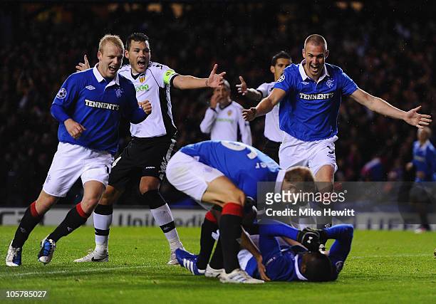 Steven Naismith, Steven Whittaker and Kenny Miller of Rangers rush to congratulate the prone Edu of Rangers after he scored during the UEFA Champions...