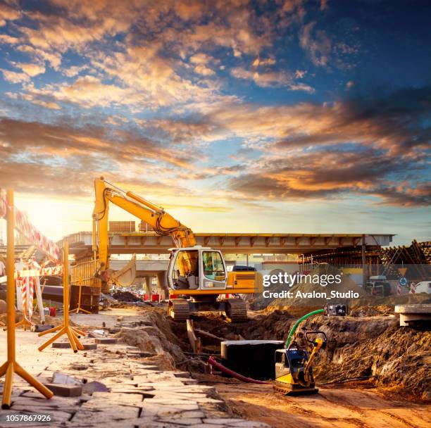 escavatore in un cantiere stradale - mining equipment foto e immagini stock