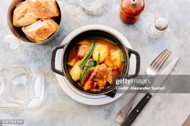 lamb stew (navarin) with vegetables served in black cast iron casserole, high angle view - fooding stock pictures, royalty-free photos & images