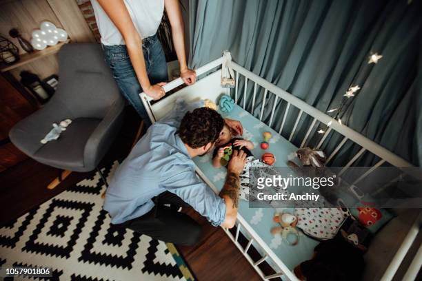 vista dall'alto di un genitori che gioca con un bambino in una culla - culla foto e immagini stock