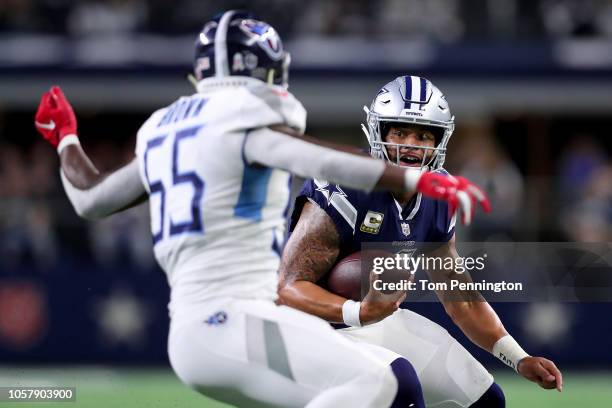 Dak Prescott of the Dallas Cowboys carries the ball against Jayon Brown of the Tennessee Titans in the fourth quarter at AT&T Stadium on November 5,...