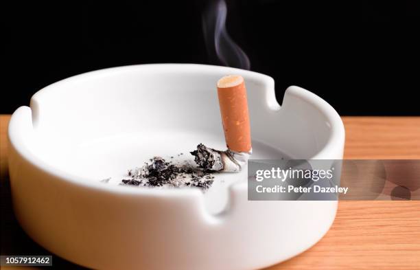 giving up smoking, cigarette butt in ahstray - extinguir fotografías e imágenes de stock