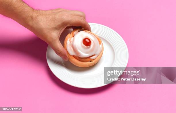 iced belgian bun on a plate - cake case stock pictures, royalty-free photos & images