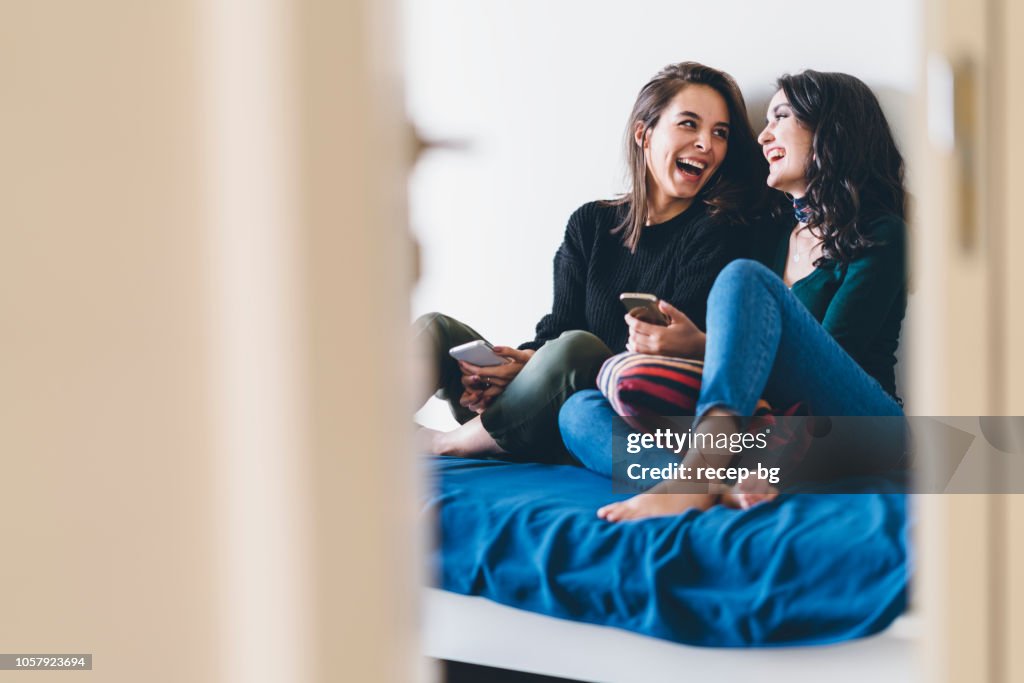 Two young women friends sharing happy time together