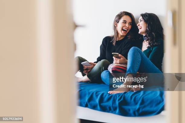 two young women friends sharing happy time together - convivio imagens e fotografias de stock