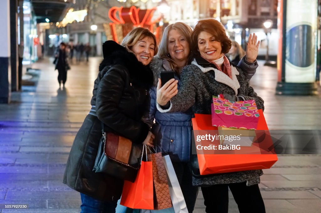 Senior vrouwen geluk winkelen in de stad bij nacht