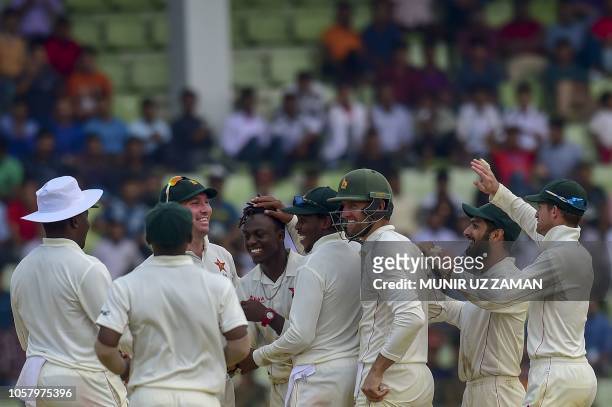 Zimbabwe cricketers congratulate teammate Brandon Mavuta after the dismissal of the Bangladesh cricketer Nazmul Islam during the fourth day of the...