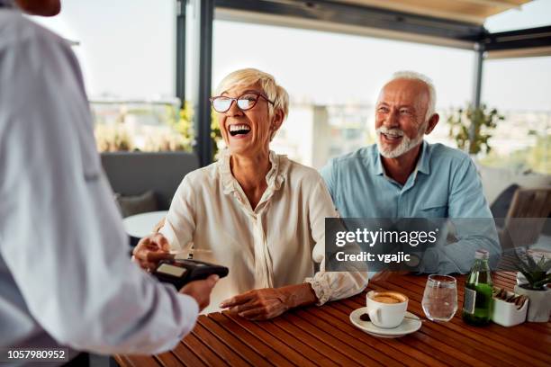 contactloze betalingen - old couple restaurant stockfoto's en -beelden