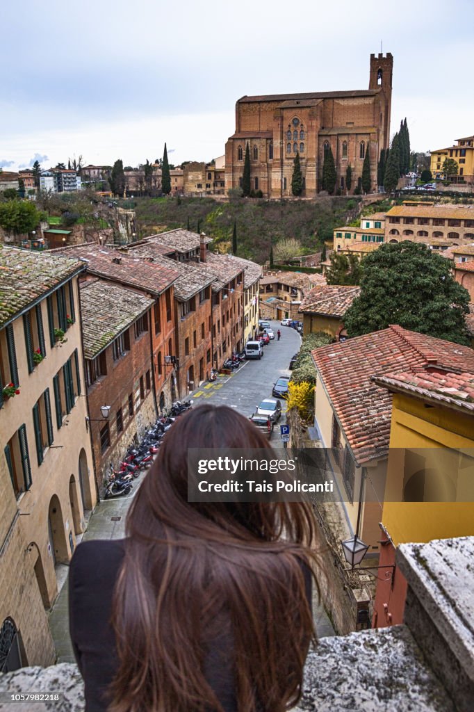 Woman looking at the Basilica di San Domenico in Siena, Tuscany, Italy