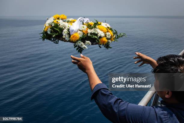 Family of victims of Lion Air flight JT 610 throw a bouquet of flowers on deck of Indonesian Navy ship KRI Banjarmasin during visit and pray at the...