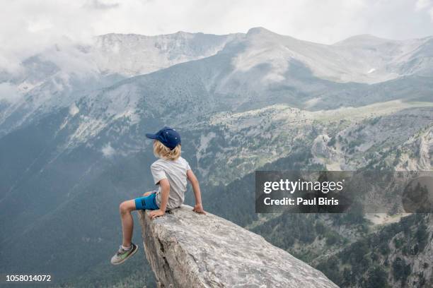 boy hiker looks off from high ridge crest, mount olympus, home of the gods of ancient greece - boy in wind stock-fotos und bilder