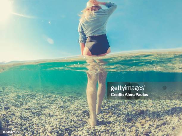 speelse jonge vrouw in de zee van split, de helft onder water helft boven achteraanzicht - half underwater stockfoto's en -beelden