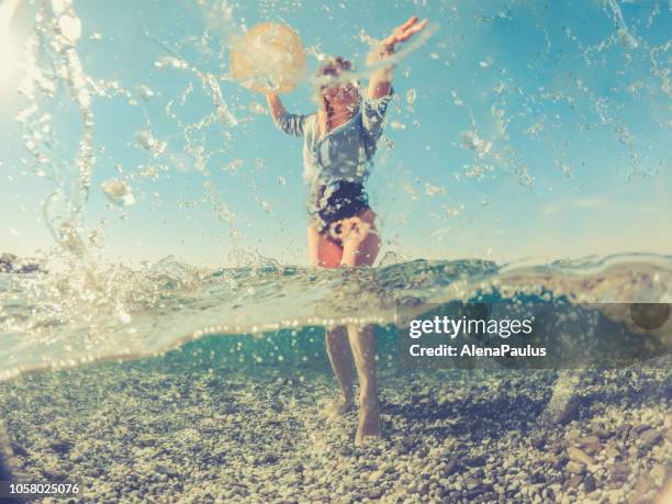 giovane donna giocosa nel mare di spalato, metà sott'acqua metà sopra - half underwater foto e immagini stock