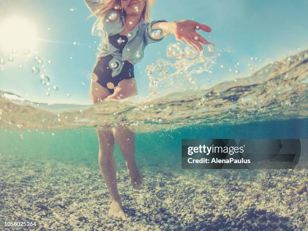 speelse jonge vrouw in de zee van split, de helft onder water helft boven - half underwater stockfoto's en -beelden