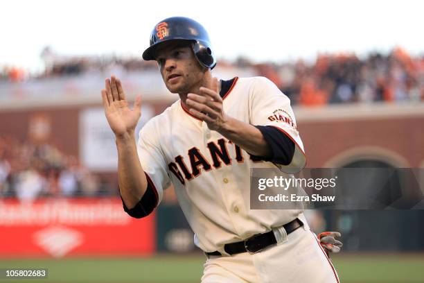Freddy Sanchez of the San Francisco Giants reacts after scoring on an RBI single by Buster Posey in the first inning of Game Four of the NLCS during...