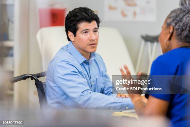 wheelchair bound man consults with doctor - serious injury stock pictures, royalty-free photos & images