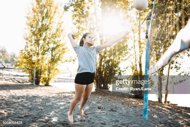 young adult women playing outdoor volleyball - beach volleyball spike stock pictures, royalty-free photos & images