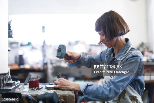 a jewellery designer working in her studio. - making stock pictures, royalty-free photos & images