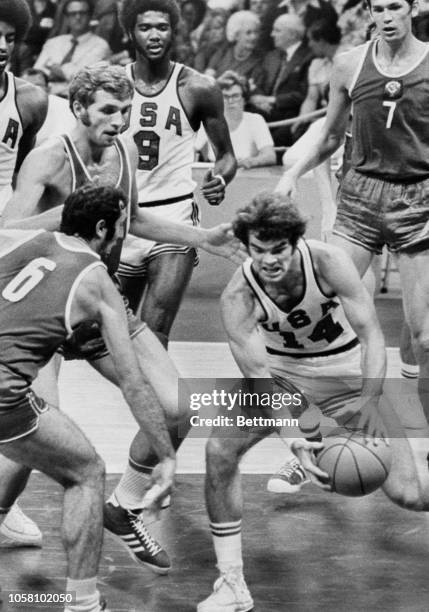 American basketballer Kevin Joyce gets his hands on the ball during the United States-USSR basketball final match here early. At left is Russian's...