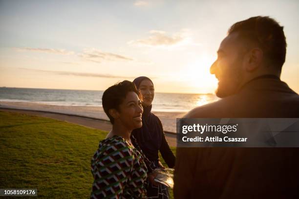 group of friends having barbecue at beach at sunset - bbq australia stock pictures, royalty-free photos & images