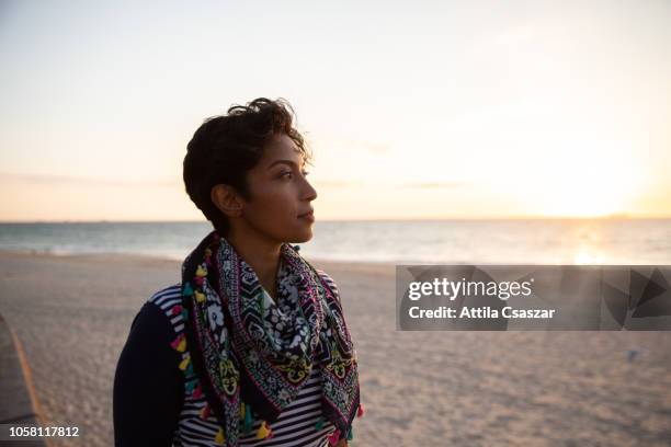 portrait of a young woman at sunset at beach - muslim woman beach stock pictures, royalty-free photos & images