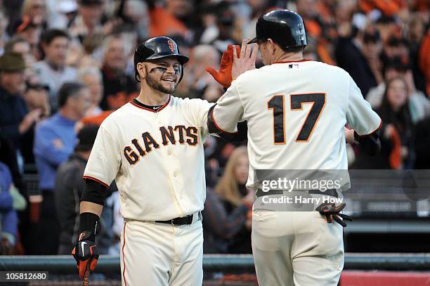 Aubrey Huff of the San Francisco Giants celebrates with Cody Ross after scoring against the Philadelphia Phillies on a double by Buster Posey in the...