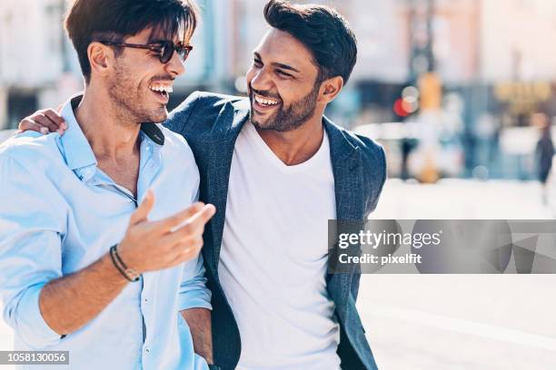 two smiling men hanging out together - men arm around shoulder stock pictures, royalty-free photos & images