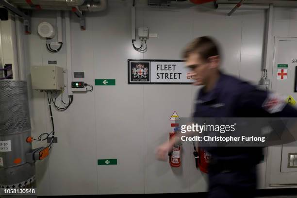 Crew member walks along Fleet Street, one of the main throughfares in the hull of HMS Queen Elizabeth. Main corridors have been named after famous...