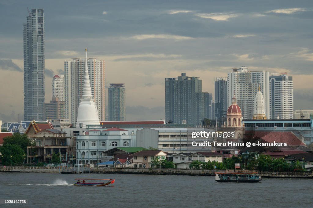 Modern city buildings and Chao Phraya River in Bangkok in the sunset