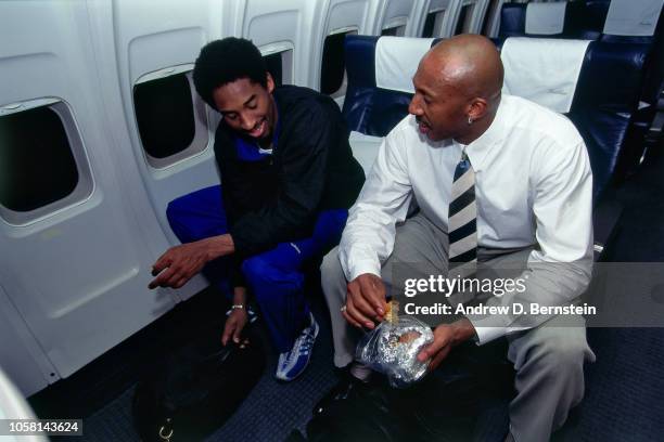 Kobe Bryant of the Los Angeles Lakers and Derek Harper talk on the airplane circa 1999 at the Great Western Forum in Inglewood, California NOTE TO...